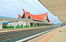 a train station with a red roof and tracks