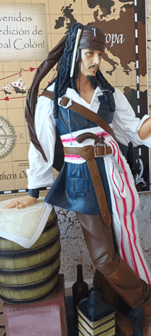 a statue of jack sparrow stands in front of a map that says " bienvenidos edicion de bal colon "