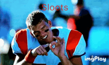 a man in a football uniform is smiling with the word sloots above him