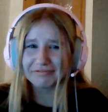 a young girl wearing headphones is crying .