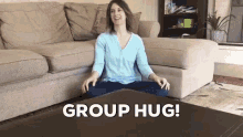 a woman sits on a coffee table in front of a couch with the words group hug written above her