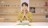 a man in a yellow shirt is sitting at a table with a bowl of food and a book titled " all taurine "