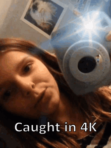 a girl is taking a picture with a camera and the caption caught in 4k