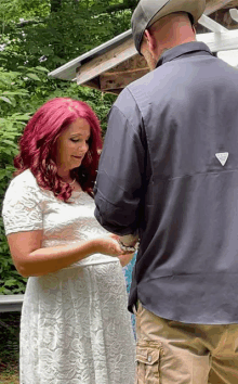 a man and a woman are holding hands and the woman has red hair