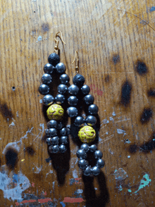 a pair of earrings made of black beads and yellow beads