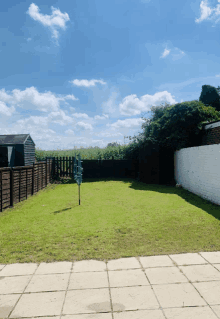 a backyard with a fence and a sign that says ' clothes line ' on it