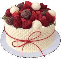 a white cake with strawberries and chocolate balls on it