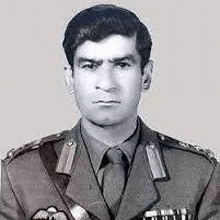 a man in a military uniform and tie is standing in front of a white background .