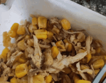 a close up of corn and chicken in a white container