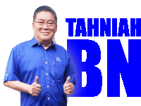 a man in a blue shirt giving a thumbs up in front of a sign that says tahniah bn