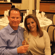 a man and a woman sitting at a table with a glass of wine