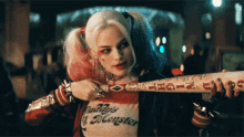 harley quinn from suicide squad is holding a bat