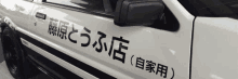 a white car with japanese writing on the side of it