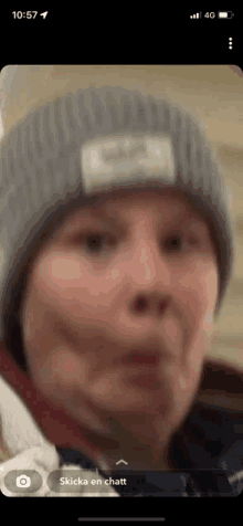 a person wearing a beanie is making a funny face on their phone