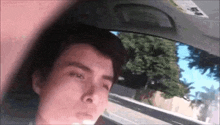 a young man is sitting in the back seat of a car .