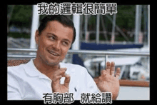 a man in a white shirt is sitting on a boat making a funny face and waving .