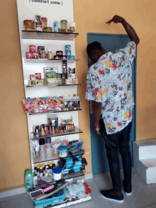 a man stands in front of a shelf with a sign that says comfort zone