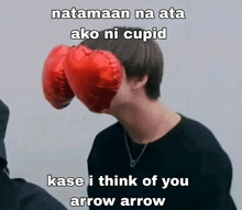 a man with a heart shaped balloon in front of his face with a caption that says " natamaan na ata ako ni cupid "