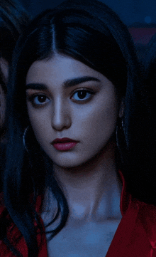 a close up of a woman 's face with dark hair and red lipstick