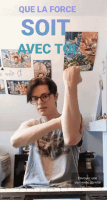 a young man with a fist in front of a sign that says que la force soit avec tou