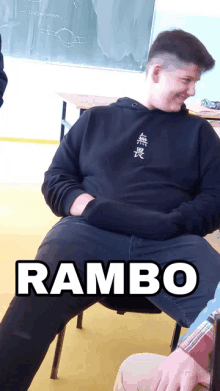 a man in a black hoodie is sitting in a chair with the word rambo on the bottom