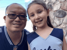 a man and a girl are posing for a picture and the girl is wearing a washington jersey