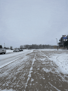 a snowy parking lot with cars parked in front of a sign that says eagle