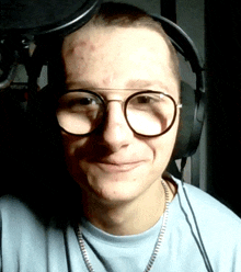 a man wearing glasses and headphones is smiling