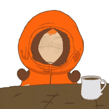 kenny from south park sits at a table with a cup of coffee in front of him