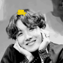 a black and white photo of a person with a yellow heart on their head