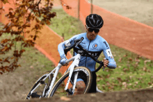 a man riding a bike with a blue shirt that says e.leclerc on it