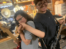 a boy and a girl playing guitars in a room