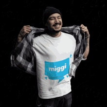 a man is wearing a shirt that says miggi