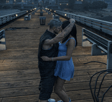 a man and a woman are kissing on a bridge