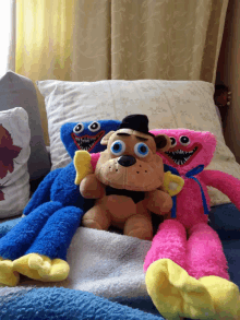 three stuffed animals are laying on a bed including freddy and pinky