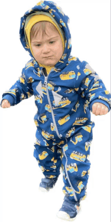 a baby wearing a blue and yellow jumpsuit with construction vehicles on it