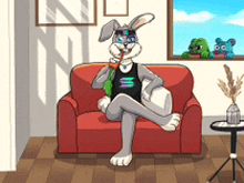 a rabbit is sitting on a red couch in a living room