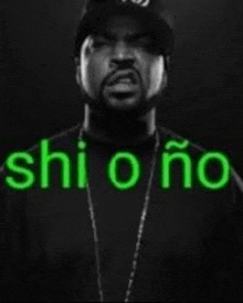 ice cube is wearing a black shirt and a hat and has the word shi o ño written on his face .