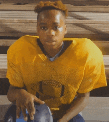 a young man wearing a yellow jersey with the letter o on the front