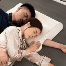 a man and a woman are sleeping next to each other on a bed with a pillow that says sleeping