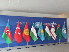 flags are lined up in front of a sign that says 7th meeting of the ministers of transport