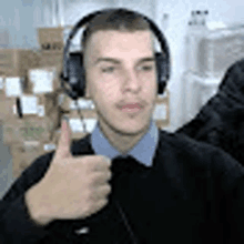 a man wearing headphones and giving a thumbs up .