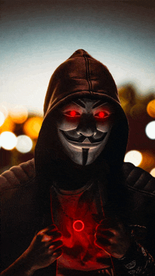 a man wearing a mask with red eyes and a hood