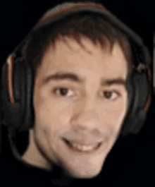 a man is wearing headphones and smiling for the camera .