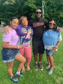 a man wearing a baltimore shirt poses with three other people