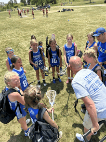 a group of young girls wearing uniforms that say brunswick are gathered in a circle