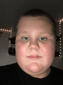 a boy 's face is shown in front of a shelf with a sign that says vb