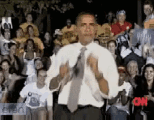 a man in a white shirt and tie stands in front of a crowd with cnn written on the bottom right corner