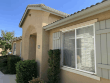 a house with a sliding glass door and shutters has a sign on the side that says ' a '