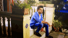 a man in a blue shirt sits on a set of stairs with a british flag sticker on the wall